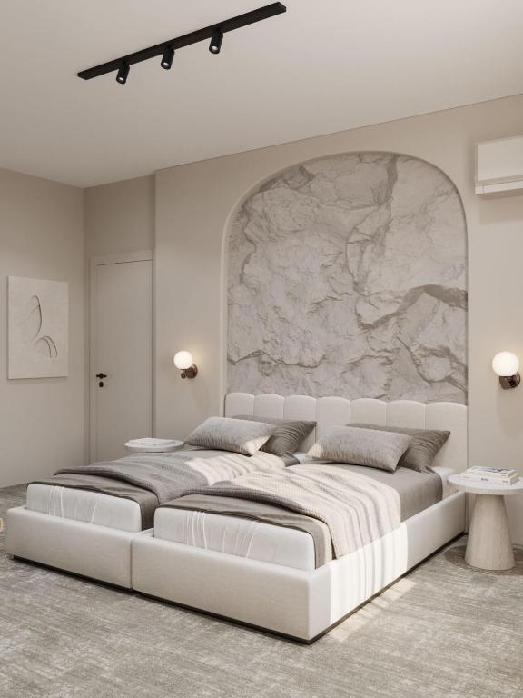 バクーにあるDastan Hotel Bakuの大きな石壁の白い部屋の大型ベッド1台