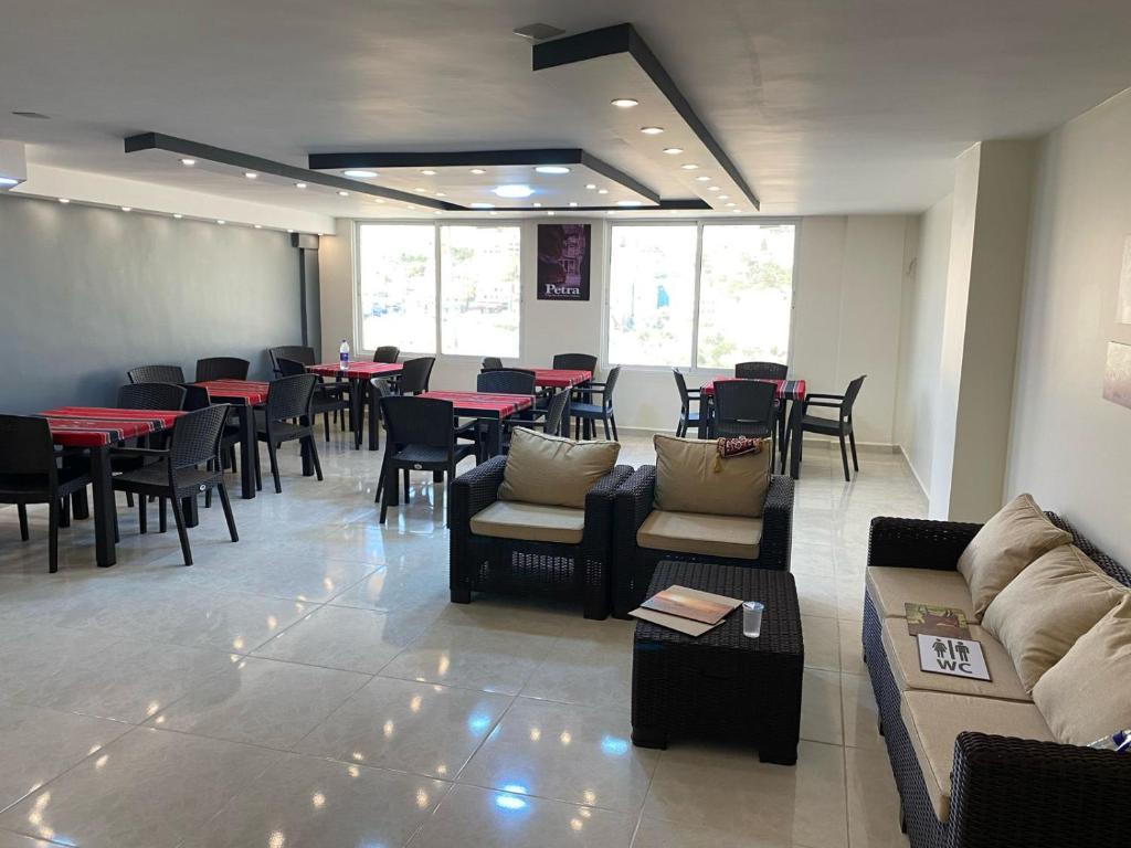 um restaurante com mesas e sofás e mesas e cadeiras em Petra rose city em Wadi Musa