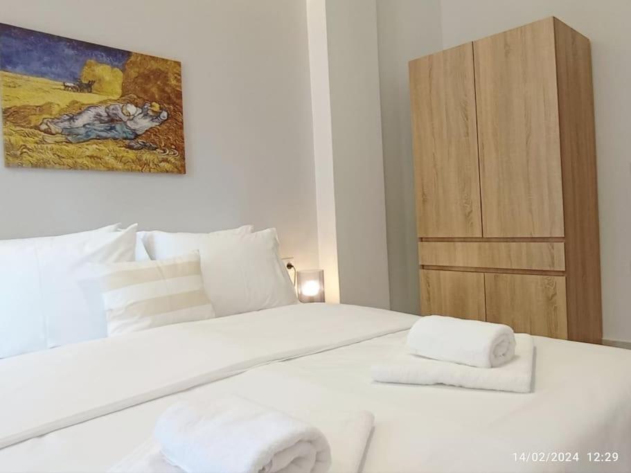 una camera da letto con un letto bianco e asciugamani di N&S Apartment A a Édessa