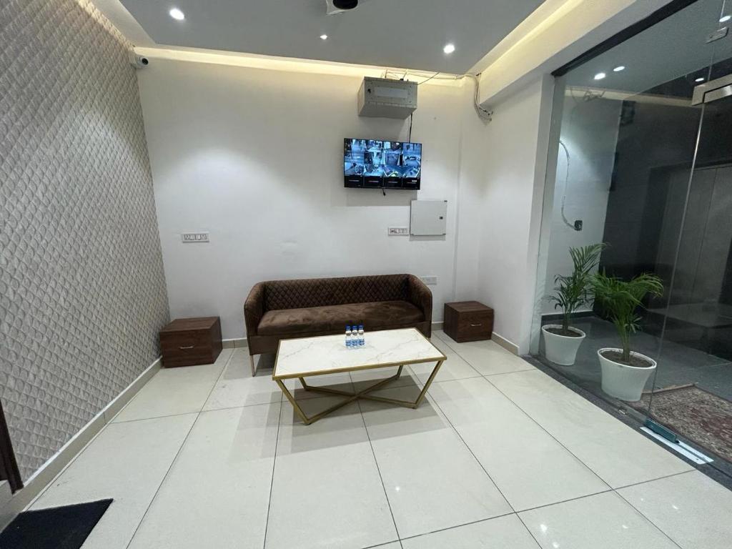 a living room with a couch and a tv on a wall at THE LUXURY PLATINUM INN --Luxury Deluxe Rooms -- Chandigarh Road in Ludhiana