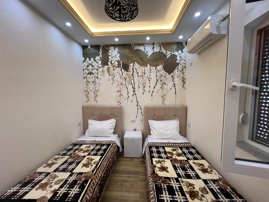 2 camas en una habitación pequeña con pared en HOTEL SYLBICA en Kolgecaj