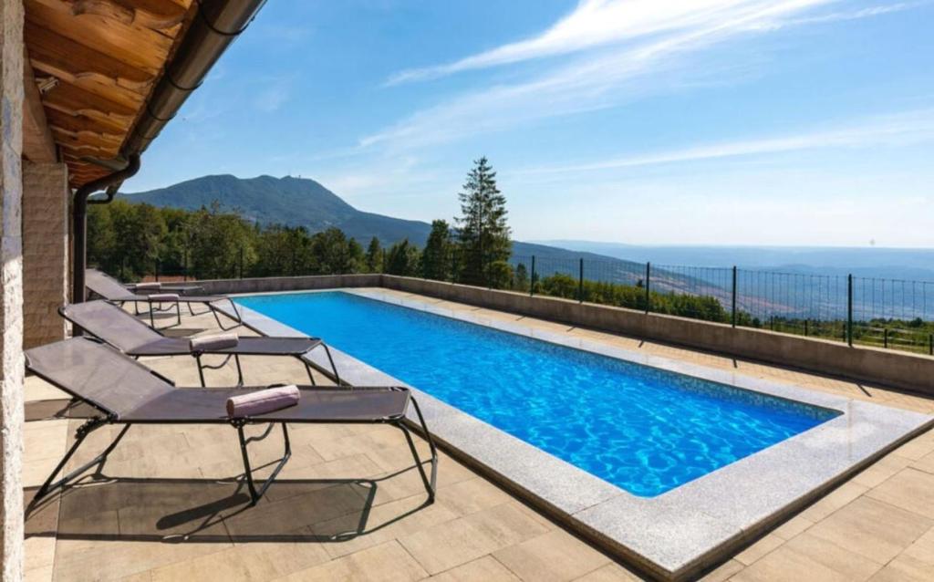 uma piscina com cadeiras e vista para o oceano em Učka nature park mountain hideway robinson house Matić with pool em Brest