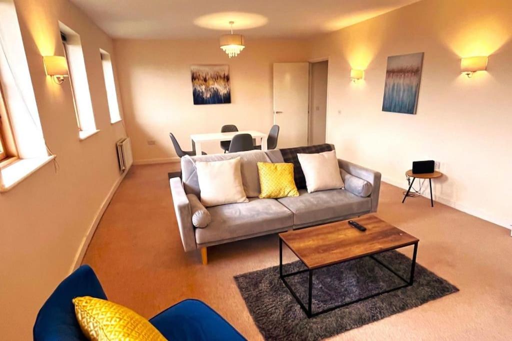 a living room with a couch and a table at Bright 2bed Flat Milton Keynes in Milton Keynes