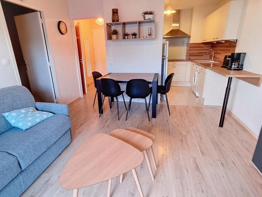 un salon avec un canapé, une table et des chaises dans l'établissement Appartement T2 Rez-de-Jardin à 50m de la Plage à Courseulles-sur-Mer - FR-1-746-16, à Courseulles-sur-Mer