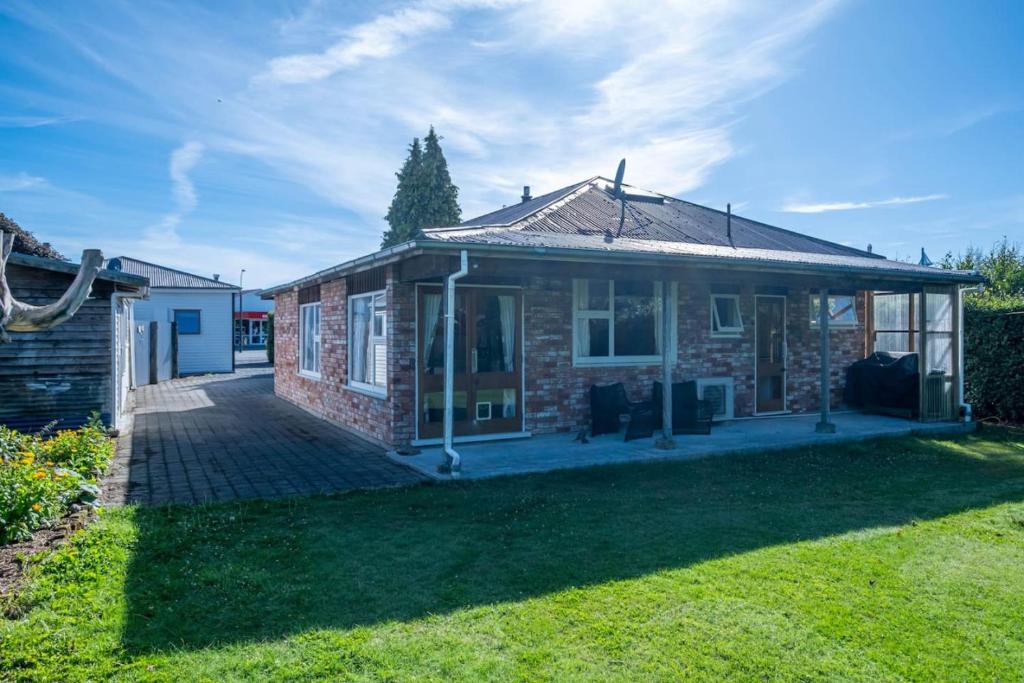 a brick house with a patio in a yard at Forest House Methven in Methven
