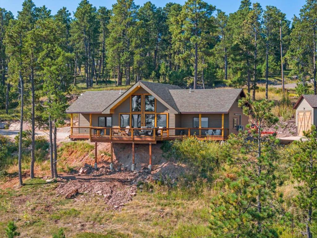 ein Blockhaus auf einem Hügel mit Bäumen in der Unterkunft Timberline Escape Overlook in Spearfish