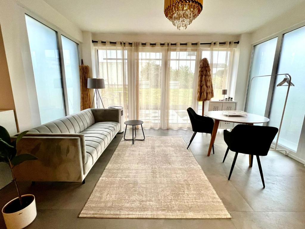 Valley of Business Dortmund - Apartment w Garden - Phoenix-See في دورتموند: غرفة معيشة مع أريكة وطاولة