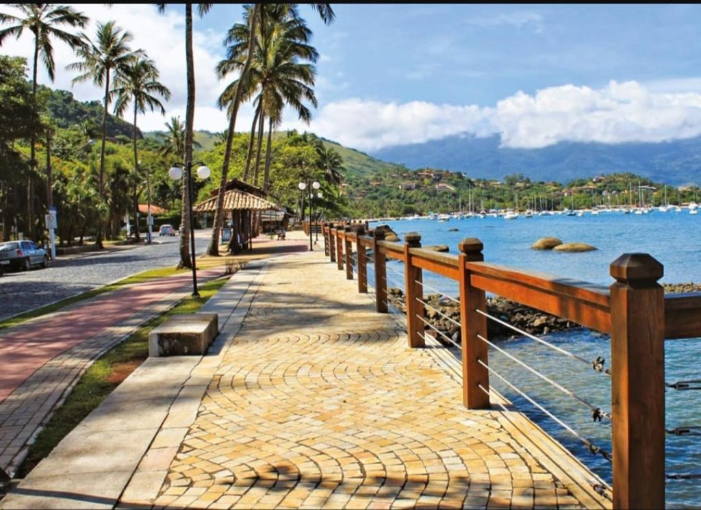 a sidewalk next to the water with a fence at Casas MDP ilhabela/2 in Ilhabela