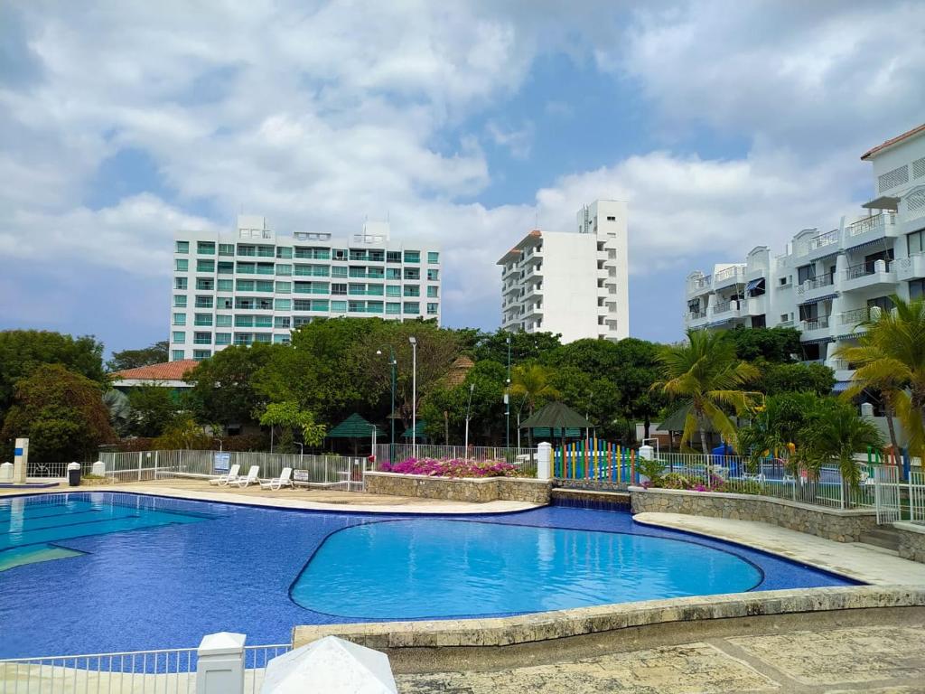 uma grande piscina azul com edifícios ao fundo em Balcones de Costa Azul Apto 302 em Santa Marta