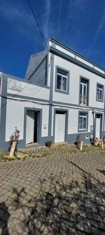a white house with two white doors on a cobblestone street at Lagos Downtown Guesthouse in Lagos