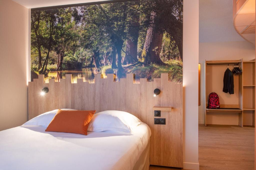 a bedroom with a large painting on the wall at The Originals City, Hôtel Alteora, Poitiers Site du Futuroscope (Inter-Hotel) in Chasseneuil-du-Poitou
