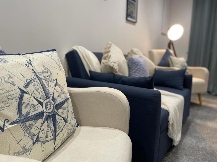 a living room with blue and white couches at The Coach House @ Barry MGroupSA in Barry