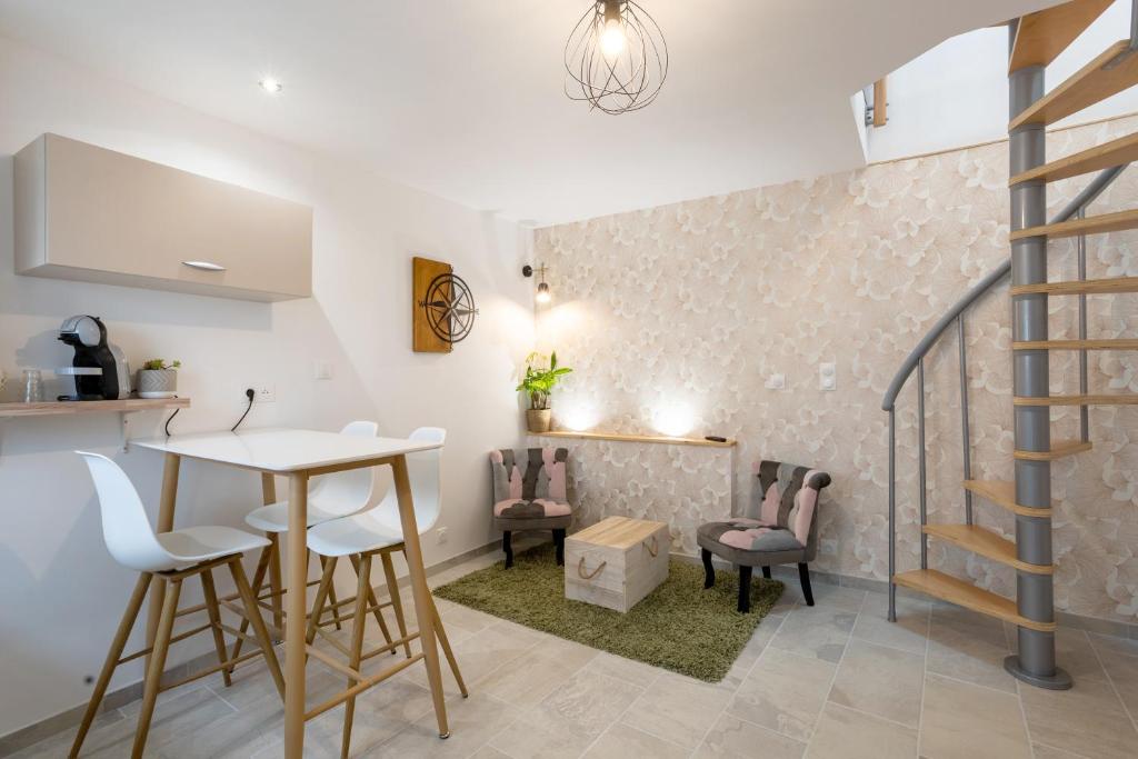 uma cozinha e sala de estar com mesa e cadeiras em Duplex de charme em Le Guilvinec