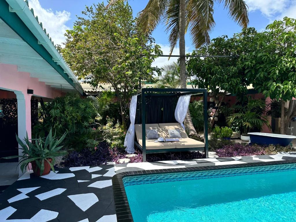 a swimming pool with a swing next to a house at Mini boutique resort exclusively for your family or friends in Willemstad