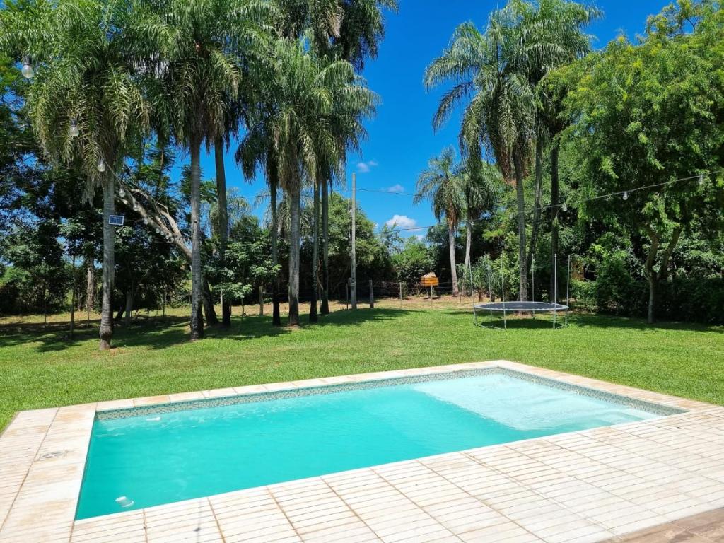 a swimming pool in a yard with palm trees at Santas Hogar in Santa Ana