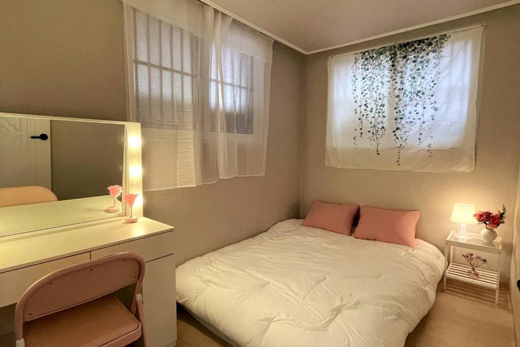 um pequeno quarto com uma cama, uma secretária e uma janela em Stay Songpa em Seul