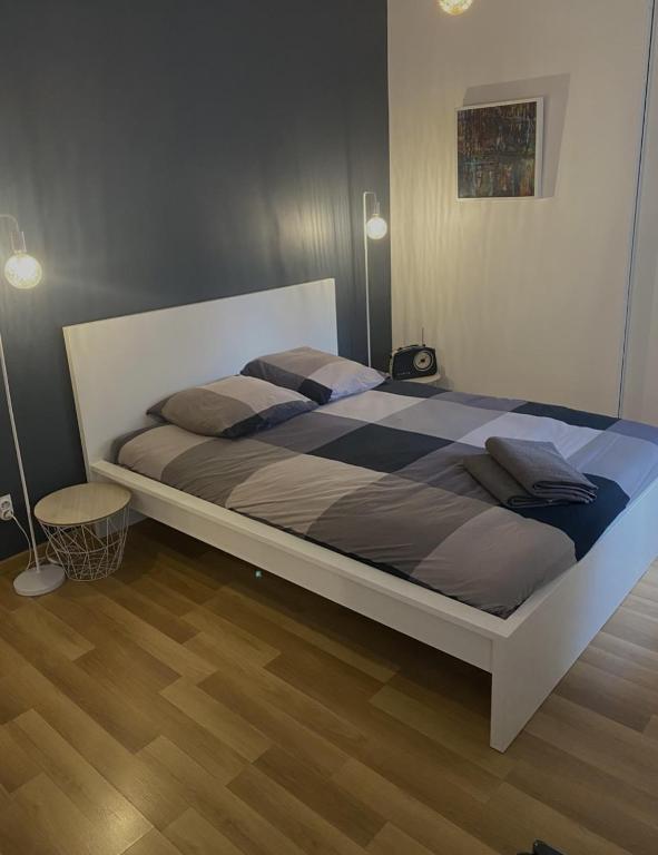 a large bed in a bedroom with a wooden floor at Chambre confort centre ville chez l'habitant in Lyon
