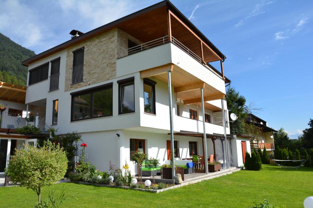 ein modernes Haus mit einem grünen Hof in der Unterkunft Ferienwohnungen Unterluimes in Telfes im Stubai