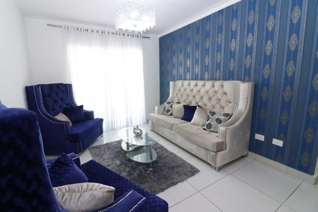 uma sala de estar com paredes azuis e um sofá e cadeiras em 3 BR apartment - READY for your stay WIFI Pool Great Location em Santiago de los Caballeros