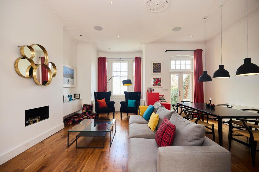 un soggiorno con divano e tavolo di The Clapham Crib - Spacious 4BDR House with Patio a Londra