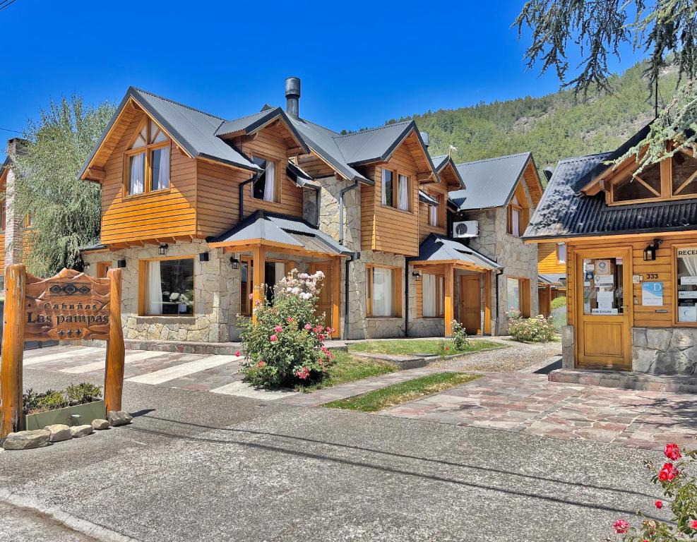 una gran casa de madera con una montaña en el fondo en Cabañas Las Pampas en San Martín de los Andes