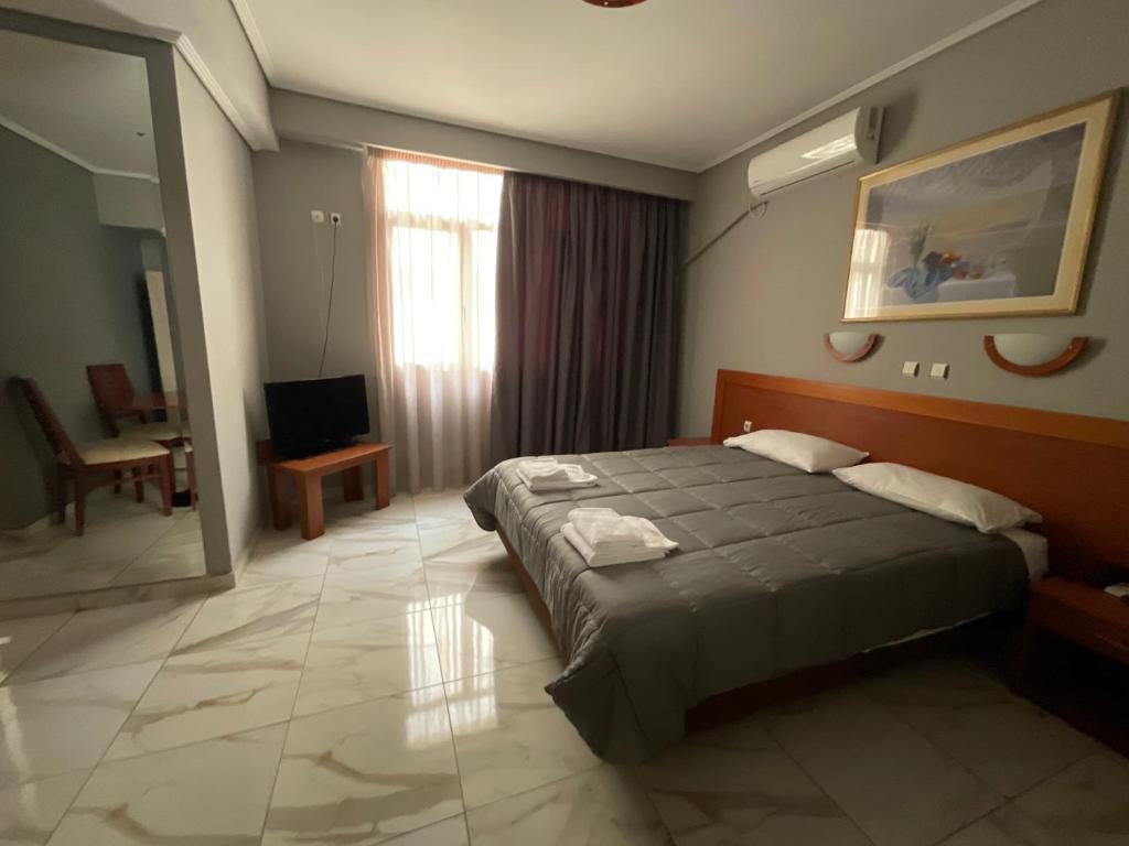 a hotel room with a bed and a window at Piraeus Acropole Hotel in Piraeus