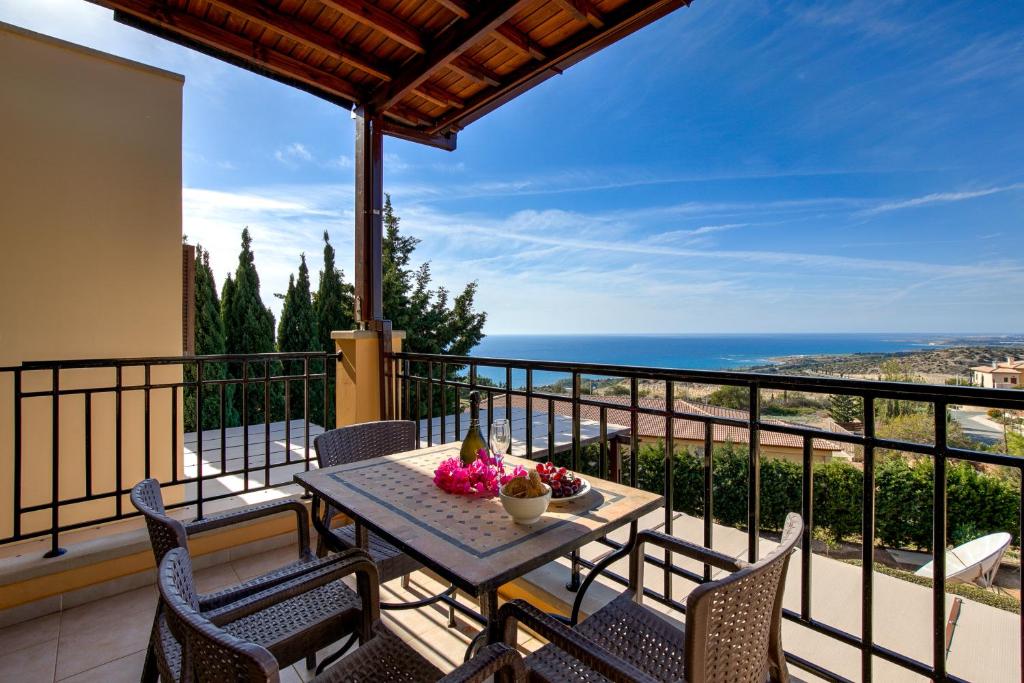 1 bedroom Apartment Pyrgos with beautiful sea and sunset views, Aphrodite Hills Resort في كوكليا: طاولة على شرفة مطلة على المحيط