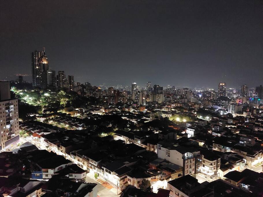 Una ciudad iluminada por la noche con una ciudad en Apartaestudio piso 19 con vista panoramica, en Sotomayor