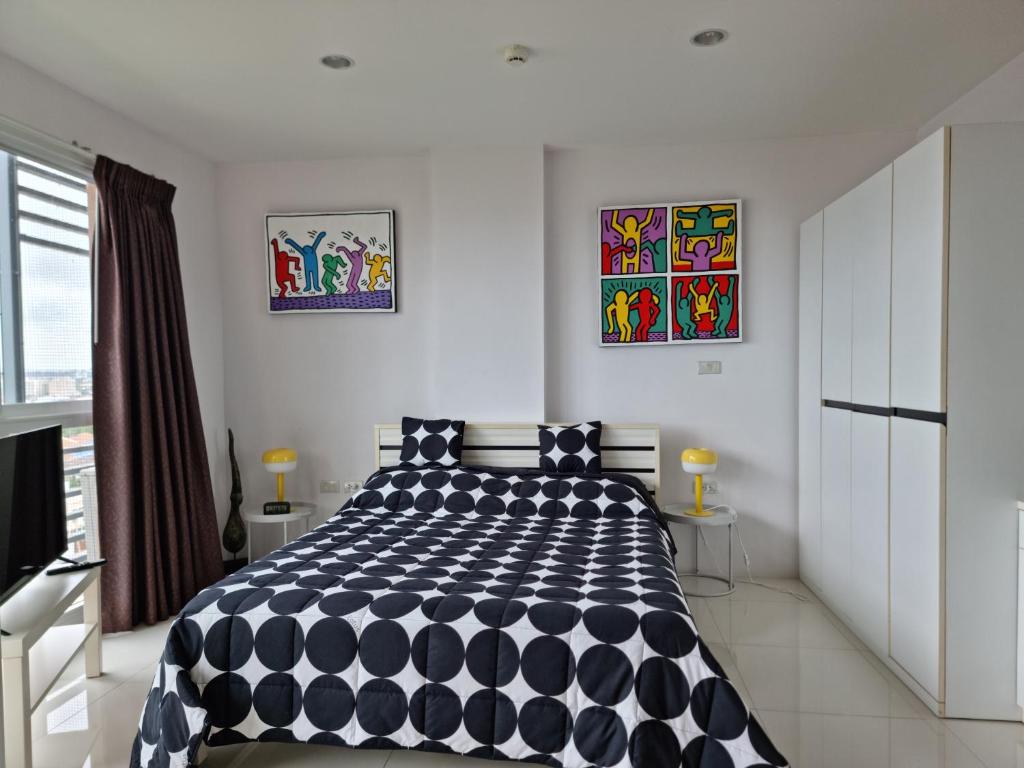 a bedroom with a black and white comforter on a bed at Diamond Suites Resort in Pattaya South