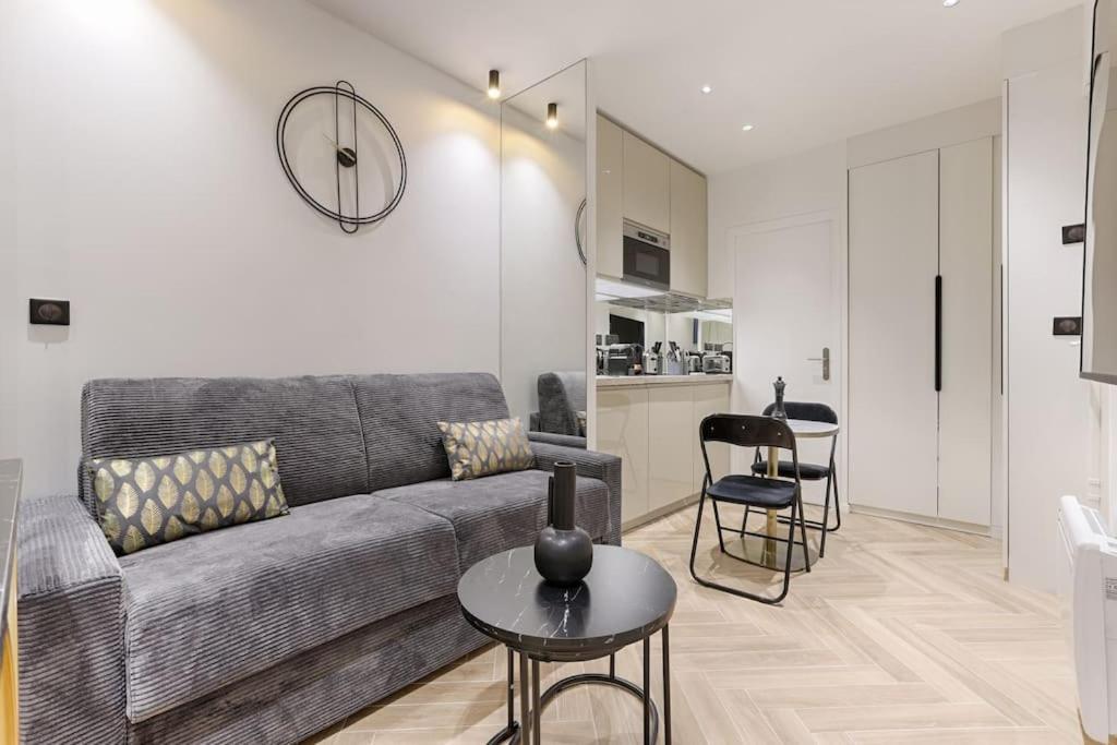 un salon avec un canapé et une table dans l'établissement Magnifique appartement Magenta, à Paris