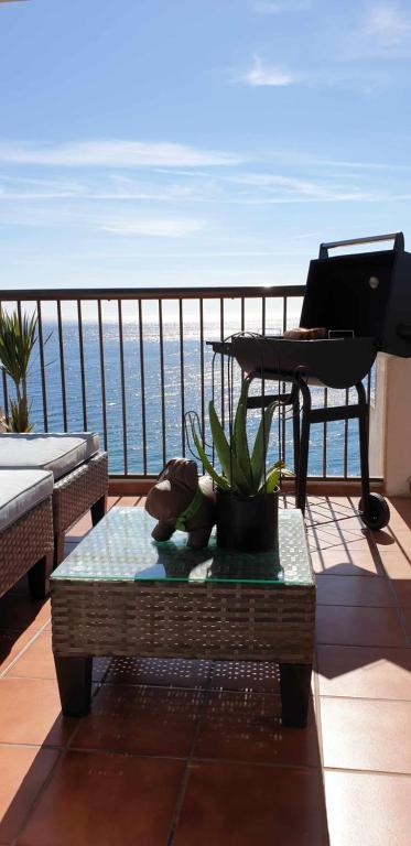 een balkon met een toetsenbord en een tafel op een balkon bij Ático con terraza frente al mar Playa Zapillo in Almería