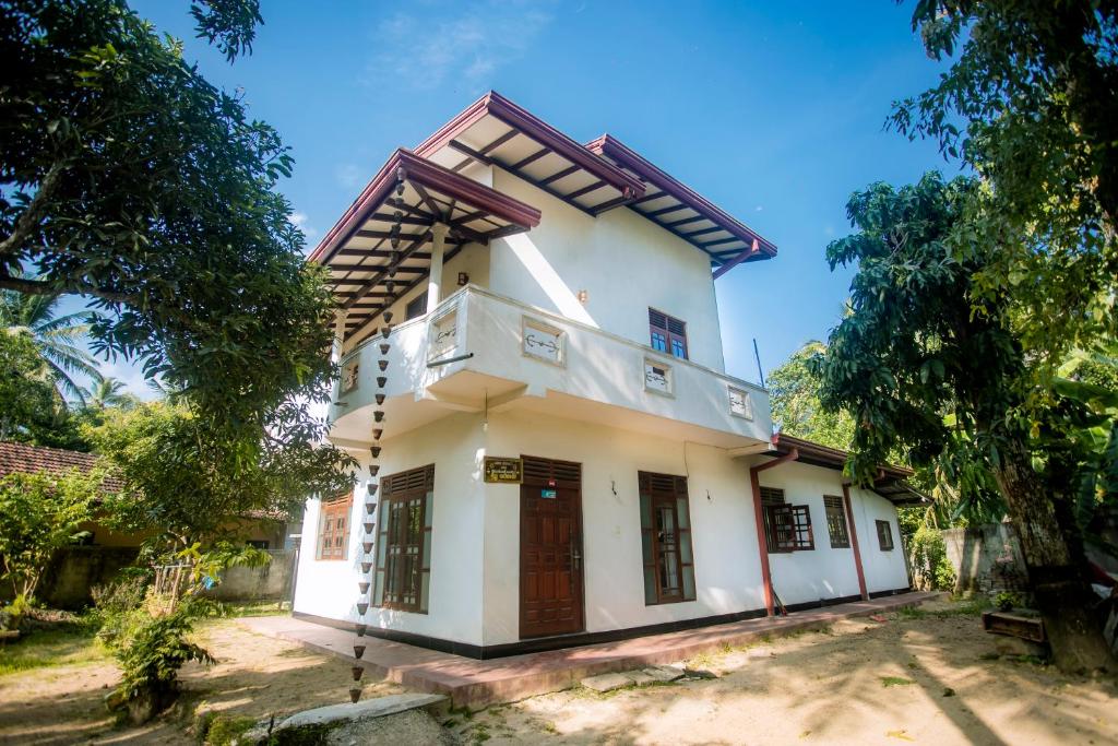 a house in the middle of a yard at Sajini Villa in Weligama