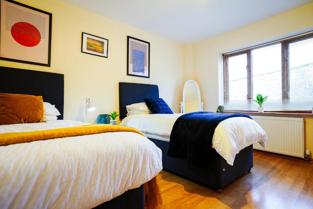 Eagle homely apartment في كيترينج: غرفة نوم بسريرين ونافذة