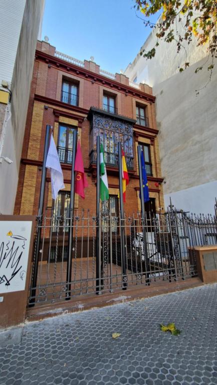 a building with flags in front of a fence at Hotel AV la Florida in Seville
