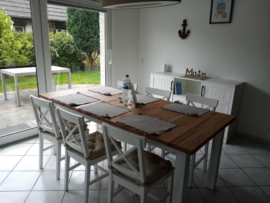 a table and chairs in a kitchen with a window at Ferienwohnung Steuerbord in Büsumer Deichhausen