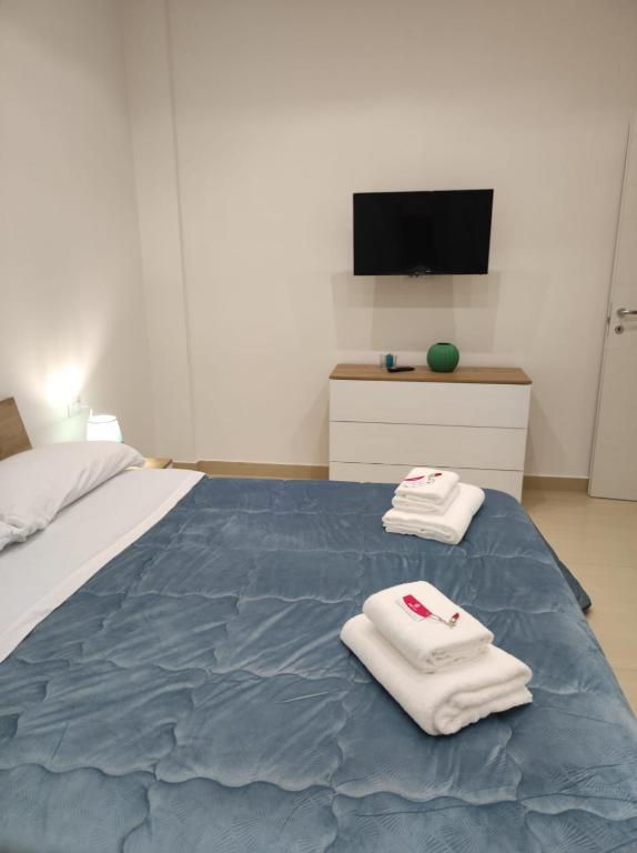 ein Schlafzimmer mit einem Bett mit zwei Handtüchern darauf in der Unterkunft MAKI HOME in Portici