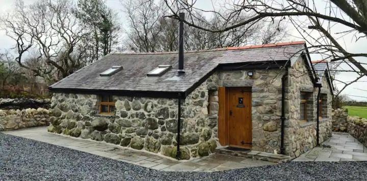 a small stone building with a wooden door at The Bothy in Caernarfon