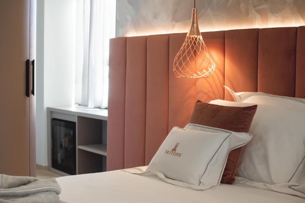 a bedroom with a bed with a headboard and a lamp at Tritone Luxury Suites Fontana di Trevi in Rome
