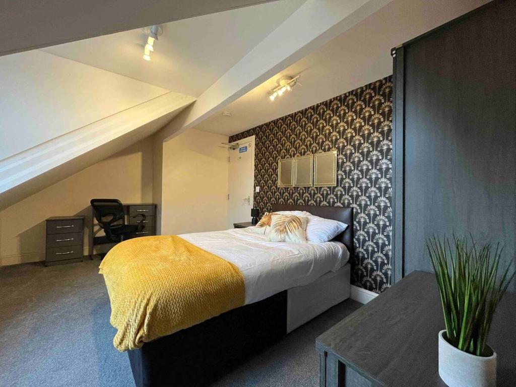 a bedroom with a large bed with a yellow blanket at Guest House 5 Beds 4 En-suites Middlesbrough in Middlesbrough