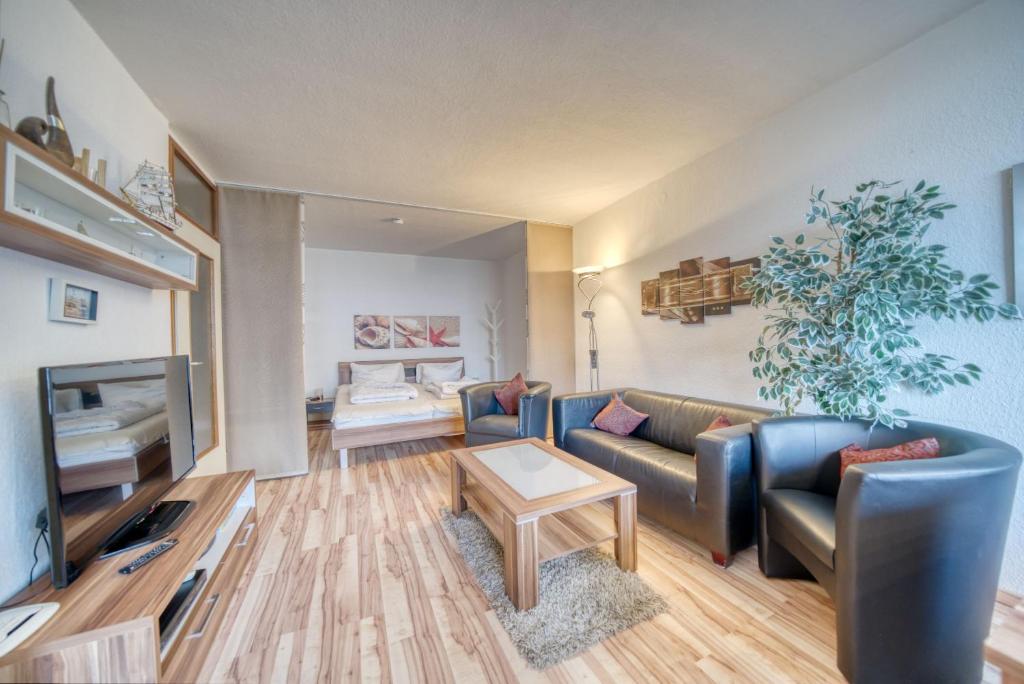 ein Wohnzimmer mit einem Sofa und einem Tisch in der Unterkunft Ferienpark - Haus N, App 0N0301 in Heiligenhafen