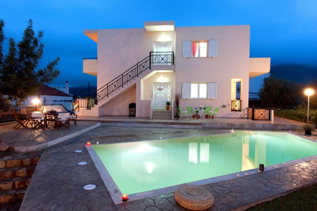 uma villa com piscina em frente a uma casa em Alura Villas em Megála Khoráfia