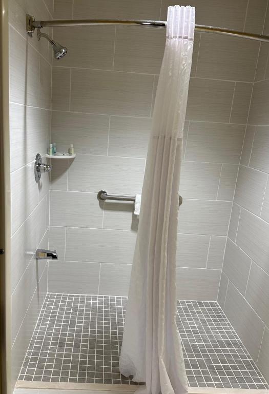 a shower with a white shower curtain in a bathroom at Quality Inn in Franklin