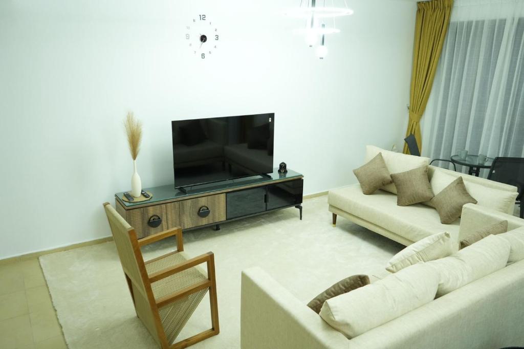 ドバイにあるCurve Hostel JBRのリビングルーム(白いソファ2台、テレビ付)