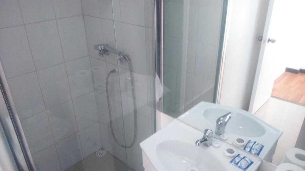 un baño con ducha y lavabo en Hostal del Rio, en Concepción