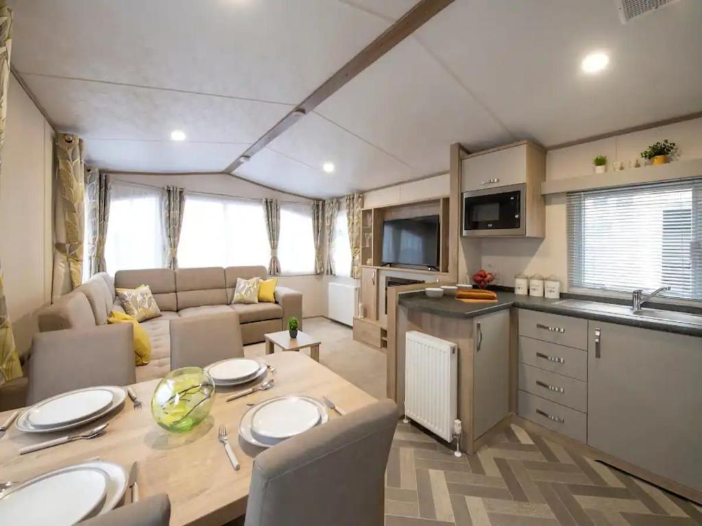 una cocina y una sala de estar con una mesa en una caravana en Pass the Keys Beautiful Cosy Holiday Home in Gorgeous Location en Beattock