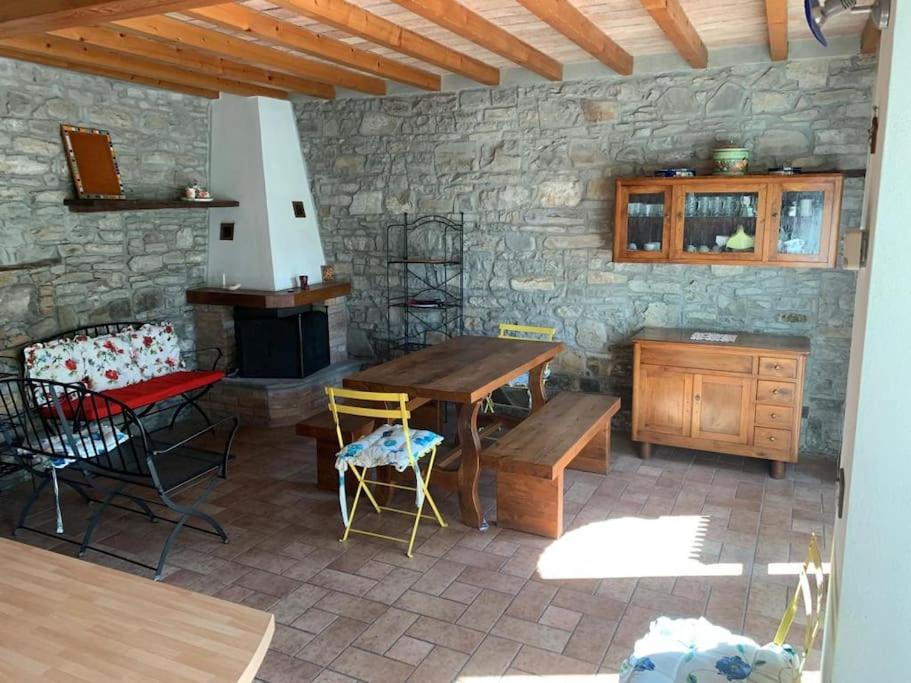 un patio con tavolo, sedie e parete in pietra di Casa in pietra in collina a Metti