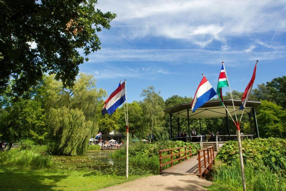 drie vlaggen in een park met een tuinhuisje bij Vakantiehuis De Zwaan in Benk en Donk