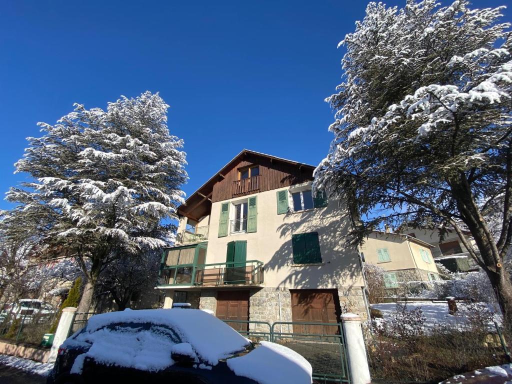 a snow covered house with a car in front of it at Villa Meyronnes in Barcelonnette