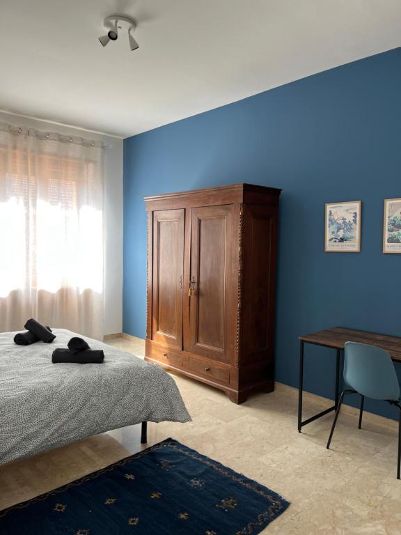 a bedroom with a bed and a wooden cabinet at Casa Marconi - City Center in Bra