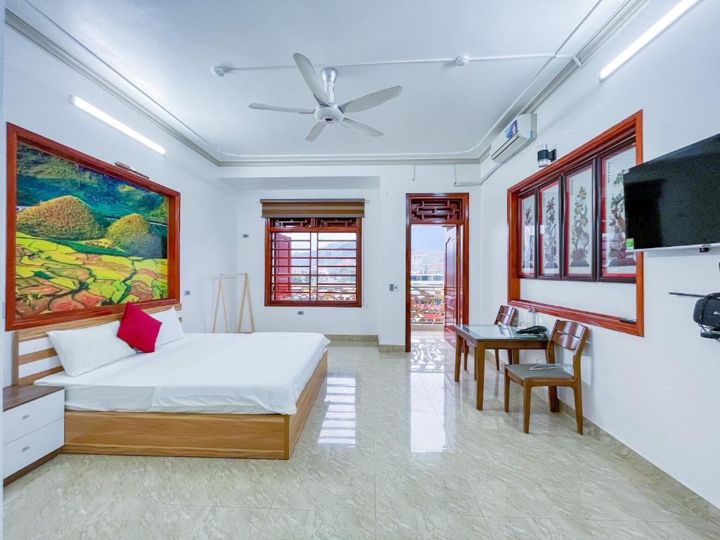 Un dormitorio con una cama y una mesa. en HagiangGo Hostel-Motorbikes rental and Tour en Ha Giang